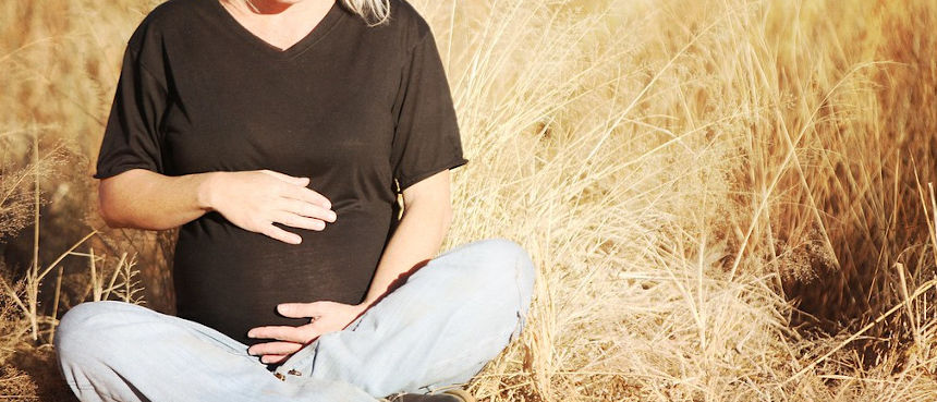 Pregnant woman sitting in a field