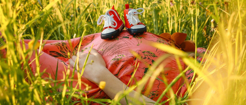 Pregnant woman laying in grass